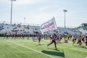 cheerleading running with eclipse flag