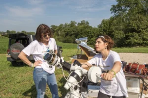 women calibrating telescope in field