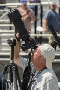 man looking through telescope during eclipse